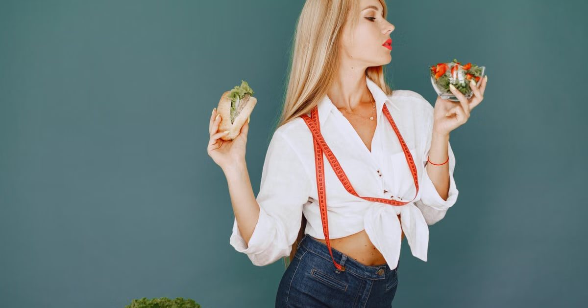 Woman enjoys healthy lifestyle with fresh salad and sandwich, promoting balanced eating.
